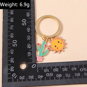 Détail du porte-clés émaillé tournesol et cactus montrant un poids de 6,9g et sa taille
