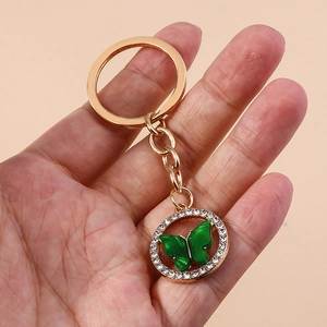Elegant gold keychain with sparkling rhinestone circle and translucent green butterfly charm