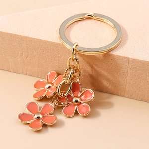Detailed macro view of triple cherry blossom charms on a gold plated floral keychain