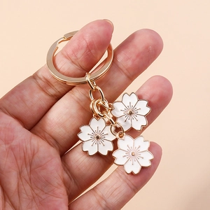 Porte-clés minimaliste fleur de cerisier avec émail blanc et anneaux en métal doré
