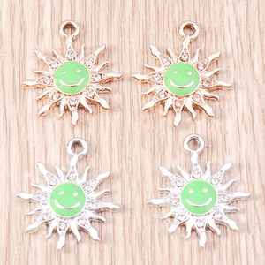 Detail of sunflower smiley pendants with green enamel inlay and rhinestone accents