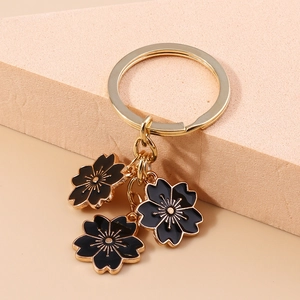 Détail du porte-clés fleur de cerisier avec émail noir et fermoir en anneau doré