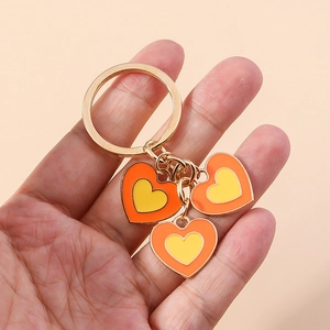 Détail du porte-clés cœur double couche avec émail orange et jaune en métal doré