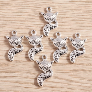 Pack of six silver alloy fox charms with antique finish on natural wood background