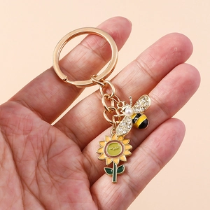 Détail du porte-clés abeille avec tournesol, finition dorée, strass et perle