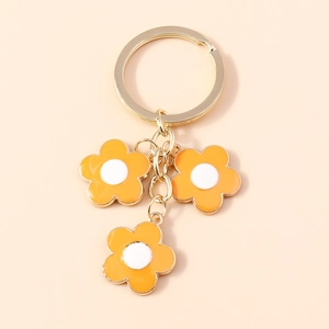 Minimalist golden keychain with three orange cherry blossom charms and enamel finish