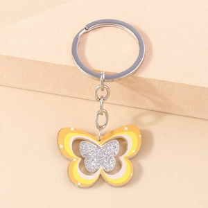 Détail du porte-clés papillon en acrylique avec paillettes argentées et anneau en métal