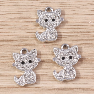 Trois pendentifs chat plaqués argent avec strass blancs sur fond bois