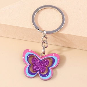 Détail d'un porte-clés papillon en acrylique avec couches pailletées et motifs d'étoiles
