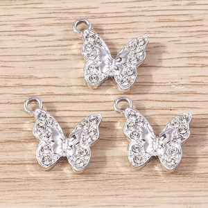 Detailed view of three silver butterfly charms with sparkling rhinestones for DIY jewelry