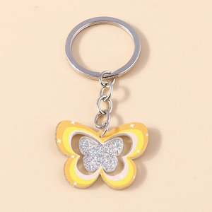 Gros plan d'un porte-clés papillon dégradé orange avec paillettes et anneau argenté