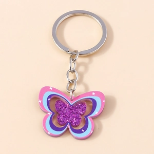 Détail du porte-clés papillon arc-en-ciel en acrylique pailleté avec anneau argenté