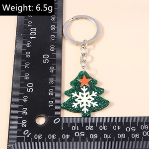 Detailed view of 6.5g Christmas tree keychain with green sequins and silver ring on a scale