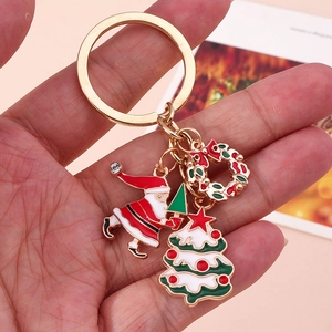 Dettaglio di un portachiavi natalizio con ciondoli smaltati di Babbo Natale e alberello