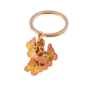 Porte-clés doré avec trois papillons émaillés orange dégradé présentés sous un angle de 45°