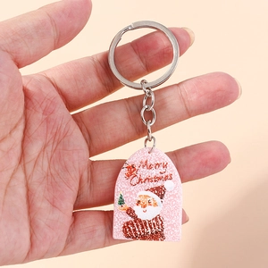 Pink Christmas keychain featuring Santa Claus and snowflake pattern held in hand