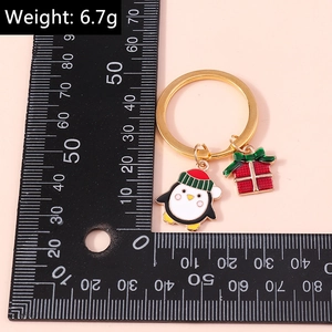 Vista dettagliata del portachiavi natalizio da 6,7g con pinguino e pacchetto regalo