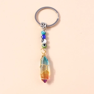 Detail of rainbow crystal hexagonal pillar keychain with gold wire wrap and evil eye beads