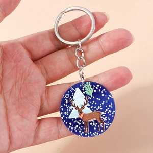 Detail shot of a blue acrylic Christmas keychain featuring a reindeer and snowflakes