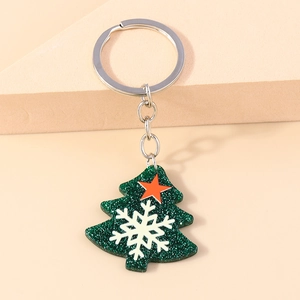 Detail of Christmas tree keychain with green glitter finish and white snowflake patterns