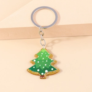 Detail of green Christmas tree keychain with white polka dots and gold glitter edges