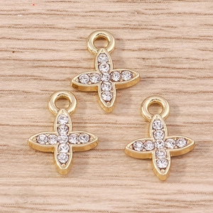 Macro detail of three gold-plated cross pendants with inlaid rhinestones and top loops