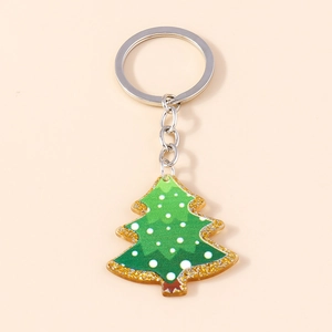 Close-up of green acrylic Christmas tree keychain with gold glitter and silver ring