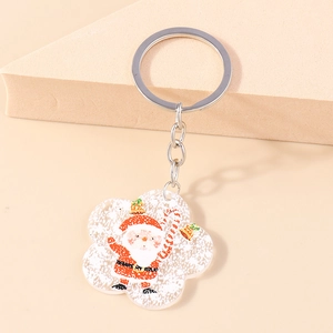 Detail of cute Santa Claus acrylic keychain with a silver metal ring on a warm background