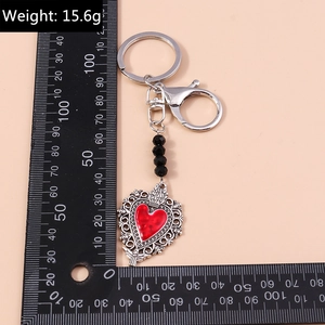 Detail of red enamel heart keychain with black beads and lobster clasp, weighing 15.6g