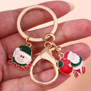 Dettaglio del portachiavi natalizio con ciondoli smaltati di Babbo Natale e elfo su anello