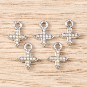 Macro detail of silver cross pendants with white pearls for DIY jewelry making
