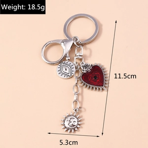 Detail showing red enamel heart and mystic evil eye charms on silver keychain