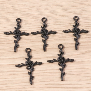Détail de pendentifs croix rose gothique noir avec motifs de vigne et anneau