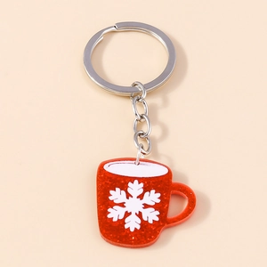 Close-up of glittery red mug-shaped keychain with white snowflake on beige background