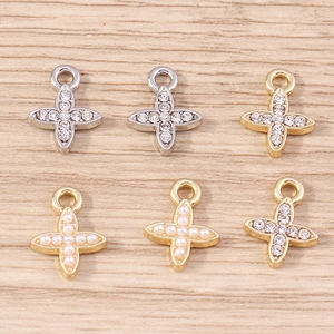 Detailed close-up of mixed gold and silver cross pendants with pearls and rhinestones