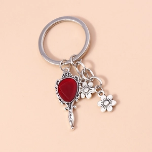 Macro shot of a vintage silver hand mirror keychain with a vibrant red heart gemstone
