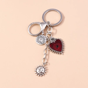 Detail of bohemian heart pendant with eye motif and sun moon charms on metal keychain