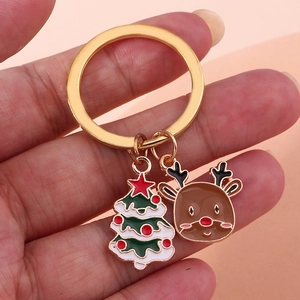 Dettaglio portachiavi natalizio con anello dorato, albero smaltato e ciondoli a forma di renna