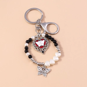 Detail of beaded butterfly and heart keychain with red metal pendant and lobster clasp