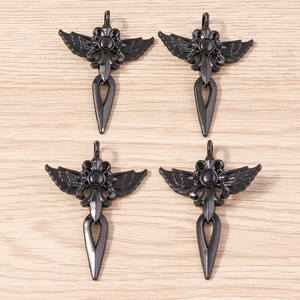 Détail de quatre pendentifs croix gothiques sombres avec rose et ailes sur bois