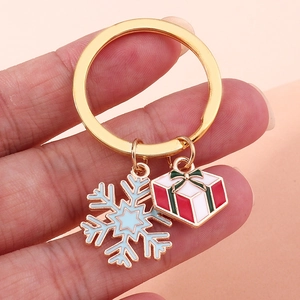 Dettaglio portachiavi natalizio dorato con fiocco di neve blu e ciondolo regalo rosso