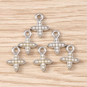 Detail of six silver cross star pendants with white pearls for DIY jewelry making