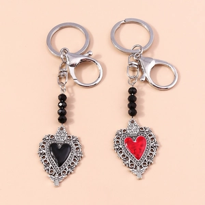 Detail of red and black heart-shaped keychains with ornate openwork metal patterns