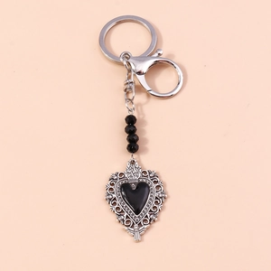 Detail of gothic silver metal keychain featuring hollow heart pendant and black beads