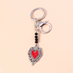 Detailed view of red heart keychain with intricate lace metalwork and black beads
