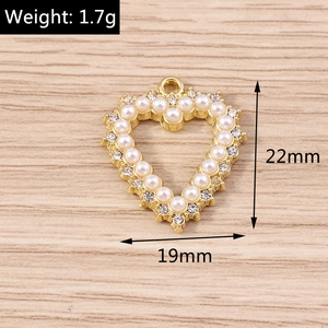 Detailed view of hollow heart pendant with pearls and crystals measuring 22mm by 19mm