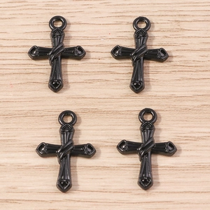 Détail de quatre pendentifs croix gothiques noirs évidés sur un fond en bois