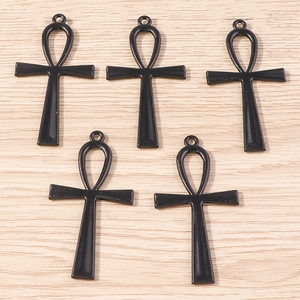 Lot de cinq pendentifs croix rose en alliage noir sur fond de bois naturel