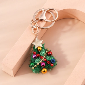 Detail of Christmas tree keychain with green velvet, colorful beads, and golden star