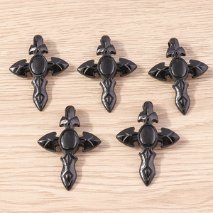 Vue détaillée de pendentifs croix gothiques noirs avec gravures de roses sur bois
